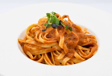 Beyaz tabakta domates soslu erişteli bolonez.