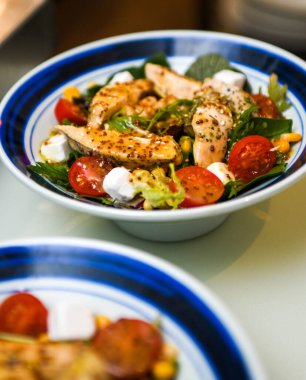 Tavuk salatası, kiraz domatesleri, Yunan peyniri ve roka