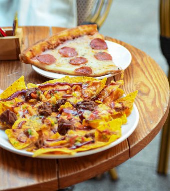 Nachos with meat and cheese on the table in a restaurant clipart