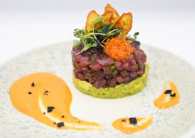 Lokantada beyaz bir arka planda avokadolu ton balıklı tartar.