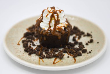 Krem şantili çikolatalı kek ve beyaz arka planda çikolata parçaları.