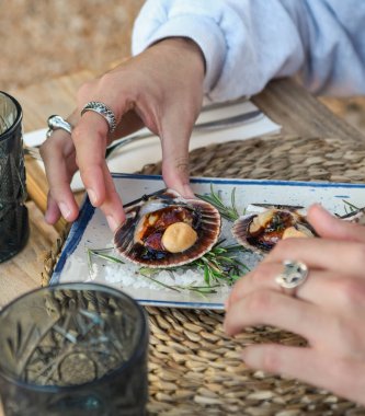 Beyaz tabakta biberiyeli taze çiğ deniz tarakları..