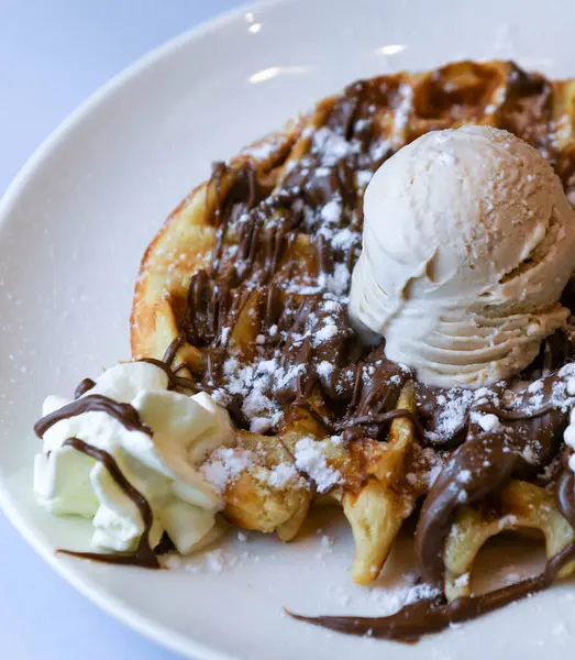 Belçika waffle 'ı, dondurma, çikolata şurubu ve çırpılmış krema.