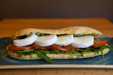 Mozzarella, domates ve roka soslu Ciabatta sandviçi.