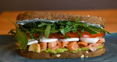 Somon, roka, domates ve mozzarella ile mısır ekmekli sandviç.