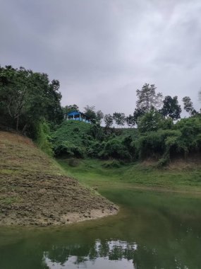 Doğanın dingin güzelliğini bu büyüleyici fotoğrafta tecrübe edin. Uzakta görkemli bir dağ sırası beliriyor, sakin bir alp gölünün kristal berrak sularında mükemmel bir şekilde yansıtılıyor.. 