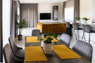 Parlak modern oturma odası iç tasarımı, yemek masası, bar tezgahı ve büyük evdeki ahşap kanepe. 