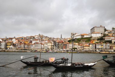 Porto 'nun Duoro nehri ile bulutlu bir günde panoramik görüntüsü, tekneli Porto şehri.