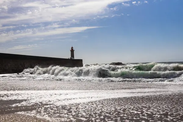 Felgueiras Deniz Feneri, Atlas Okyanusu kıyısında güneşli bir günde büyük dalgalarla Farol de Felgueiras 'ta dalgalar savruluyor.