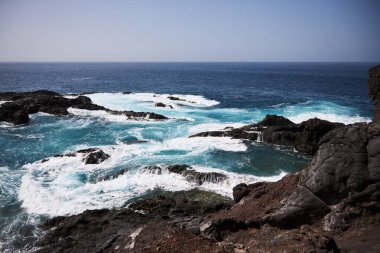Tenerife 'de mavi okyanuslu kara koy, siyah voulcanic kumu
