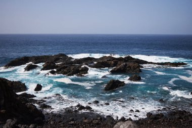 Tenerife 'de mavi okyanuslu kara koy, siyah voulcanic kumu