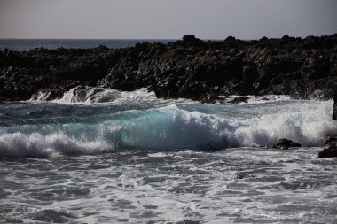 Tenerife 'de mavi okyanuslu kara koy, siyah voulcanic kumu