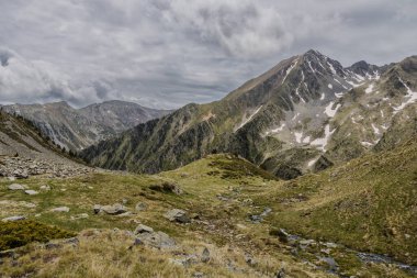 Dağın zirvesinde yaz aylarında kar ve yeşil çimlerle kaplı, Andorra dağlarında bulutlu, Arinsal