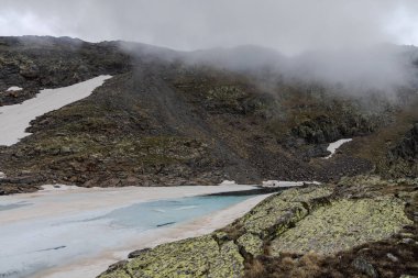 Bulutlu dağlarda parlak mavi glasier, Andorra 'da yazın Montmantell Gölü donmuş.