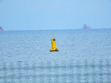 Deniz fotoğrafında sarı bir şamandıra vardı.