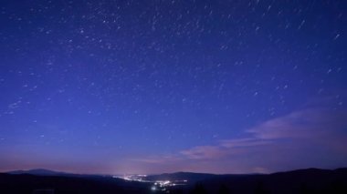 Gece Gökyüzündeki Yıldız Yolları, 4K. Yüksek kaliteli 4K görüntüler Gece gökyüzü, kırsal alanda Samanyolu, gece parlayan şehir