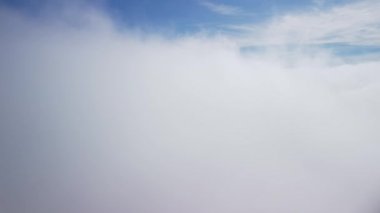 Güzel, kalın, kabarık bulutlar arasında uçuyor. Saf gün ışığında açık mavi gökyüzünde yavaşça hareket eden yumuşak beyaz bulutların şaşırtıcı zamanlaması. Kokpitten direkt görüntü. Yüksek kalite 4k görüntü