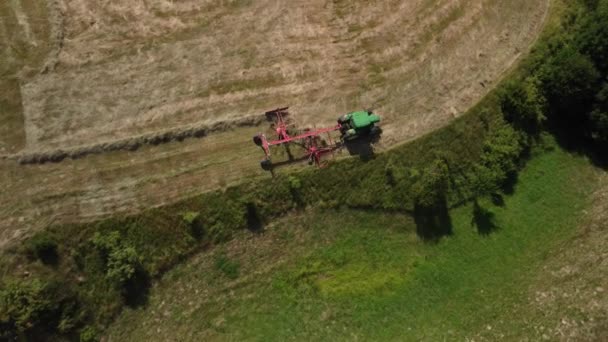 農家は収穫された干し草をトラクターのテダーの助けを借りて動かすことで 干し草の乾燥をスピードアップします トップ ワイフ 高品質4K映像 — ストック動画