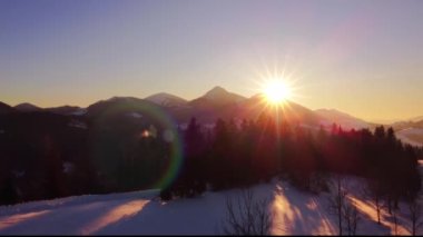 Aerial view of colorful sunrise in early spring nature country with snowy meadow in mountain nature. High quality 4k footage