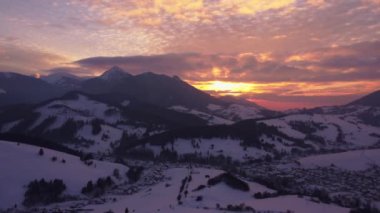 Aerial view of sunset, Orange clouds , winter rural landscape in mountains. High quality 4k footage