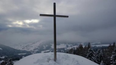 Kış mevsiminde bir Hristiyan haçı. Bulutların katmanları, parlayan güneş ışınları, zaman ayarlı, uzaklaşın. Yüksek kalite 4k görüntü