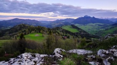 Dağlık dağ manzarası ormanlar, çayırlar ve altın saatinde zengin bahar renklerinde dağlarla dolu. Yüksek kalite 4k görüntü