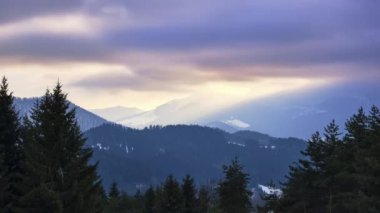 Gün batımında karlı bir tepe kırsal alanda bulutlar. Turuncu renkli bulutlar, hızlandırılmış zaman. Yüksek kalite 4k görüntü