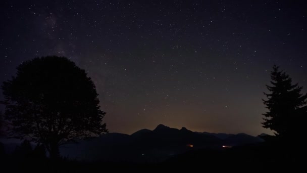 Night Sky Met Melkweg Sterren Wolken Heuvelachtig Landschap Met Bomen — Stockvideo