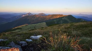 Batan güneşin ışığı ve gölgesi, sonbahar dağ manzarası olan Karpat Dağları 'ndaki bir dağ sırasını aydınlatıyor. Yüksek kalite 4k görüntü