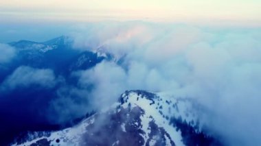Karpatya Dağları 'ndaki karlı dağların üzerinden bulutların üzerinden ileri doğru olan hava görüntüsü, yüksek hız. Yüksek kalite 4k görüntü