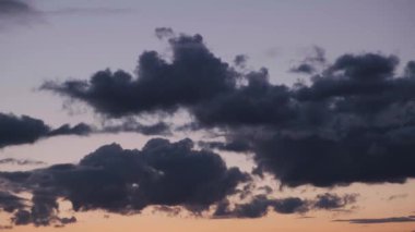 Atmosfer. Gün batımında ya da günbatımında hava. Kara bulutlar ağır çekimde. Güzel bir akşam ve mavi gökyüzü. Ses ötesi ışık efekti. Kümülüs bulutu. İklim tahmini. Bulutlar gökyüzünde akıyor. Yüksek kalite