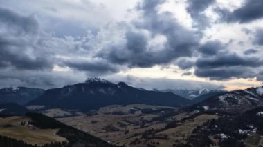 Kış ve bahar arasındaki kırsal dağ manzarası, bulutlu hava, dağların üzerinde oluşan bulutlar, zaman çizelgesi. Yüksek kalite 4k görüntü