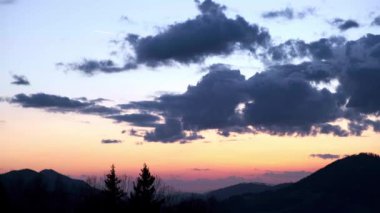 Gökyüzünde bulutların yavaş hareketi, alacakaranlıkta Hilly manzarası. Yüksek kalite 4k görüntü