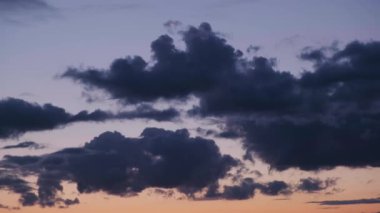 Atmosfer. Gün batımında ya da günbatımında hava. Kara bulutlar ağır çekimde. Güzel bir akşam ve mavi gökyüzü. Ses ötesi ışık efekti. Kümülüs bulutu. İklim tahmini. Bulutlar gökyüzünde akıyor. Yüksek kalite