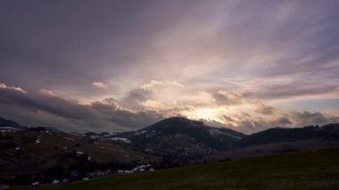 Akşam gökyüzü dramatik tepeler ve köyler üzerindeki bulutlarla, doğal güzelliğin resimli bir sahnesi. Kırsal ve kırsal dağların karışımı.,