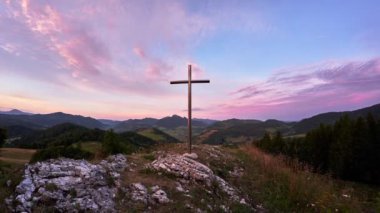 Bir dağ manzarasında Hristiyan haçı, dağların üzerinde dramatik bulutlar. Yüksek kalite 4k görüntü