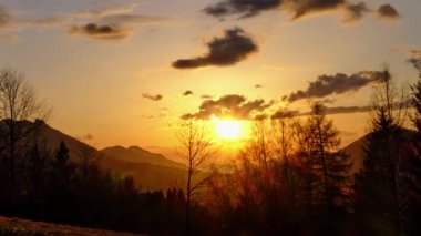 Ormanın kenarındaki tepelik kırsal bir arazide gün batımı, Timelapse. Yüksek kalite 4k görüntü