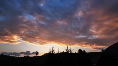 Kendinizi nefes kesici güzelliğe daldırın çarpıcı bir günbatımına eşlik eden, canlı bulutların tamamen huzurlu ve huzurlu bir manzaranın üzerinde bir tuval çizdiği yere.