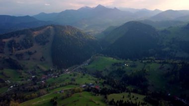 Kendini yemyeşil tepelerin huzur dolu güzelliğine ve nefes kesen bu hava görüntülerine tutulan görkemli dağlara daldır.
