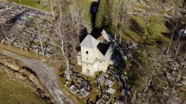 Kırsal Arazi 'deki bir mezarlığın ortasındaki eski bir kilisenin insansız hava aracı görüntüsü. Dönen Manzara. Yüksek kalite 4k görüntü