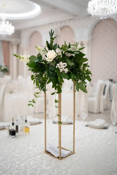 Wedding centerpieces, with metal vase and green fresh flowers arrangements. Wedding day. Wedding decor.