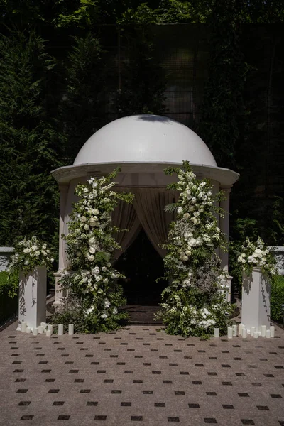 Wedding arch with white and pink roses. The arch is decorated with flowers. Wedding decor.