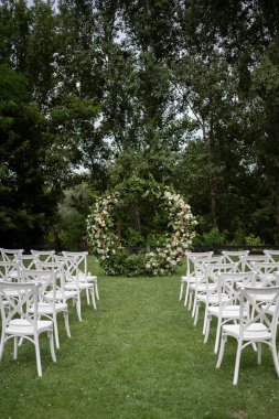 Düğün töreni. Çok güzel ve şık bir düğün kemeri, çeşitli taze çiçeklerle süslenmiş, bahçede duruyor. Düğün günü. Taze çiçek süslemeleri, şakayıklar..