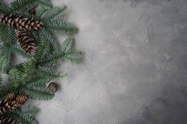 Noel kompozisyonu. Noel süslemeleri, çam kozalakları, gri taş arka planda köknar dalları. Düz konum, üst görünüm, kopyalama alanı