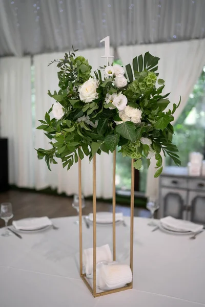 Wedding centerpieces, with metal vase and white fresh flowers arrangements. Wedding day. Wedding decor.