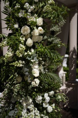 Beyaz ve pembe güllü düğün kemeri. Kemer çiçeklerle süslenmiş. Düğün dekoru.