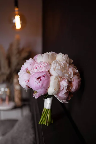The bride's bouquet of pink peonies on dark backround. Sarah Bernard peonies.