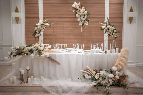 Wedding table set up in boho style with pampas grass and greenery, soft focus. Wedding day.