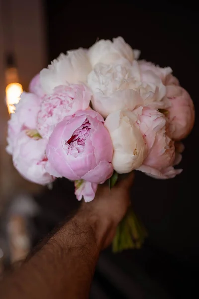 The bride\'s bouquet of pink peonies on dark backround. Sarah Bernard peonies.