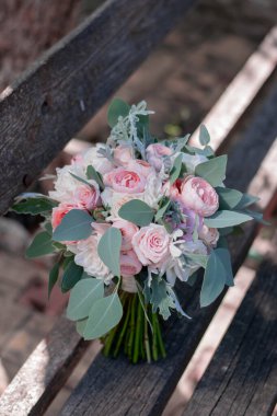 Pink bridal bouquet with ribbons. Wedding bouquet composed of roses and eucalyptus